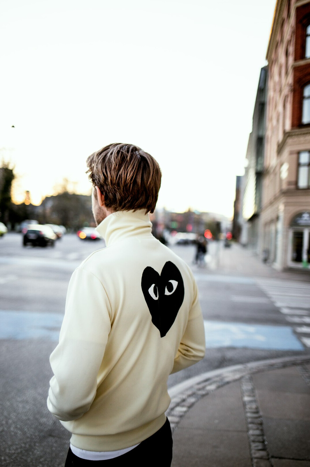 Candid street portrait of a young Danish man on a cobblestone street